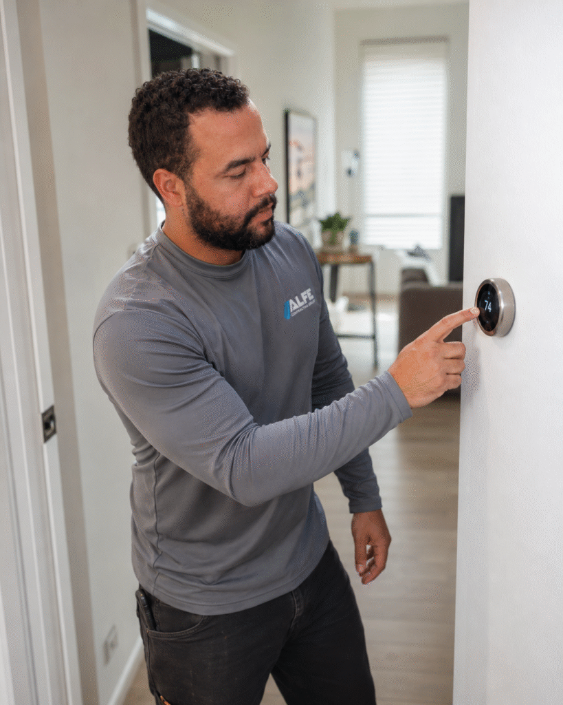 Certified Alfe Construction technician installing a smart thermostat in a residential home in Orlando, Central Florida